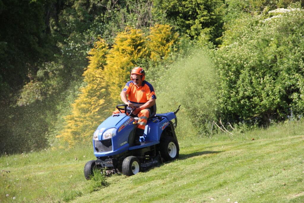 Clearing ground on sit and ride tractor Cutting long grass with a sit on mower